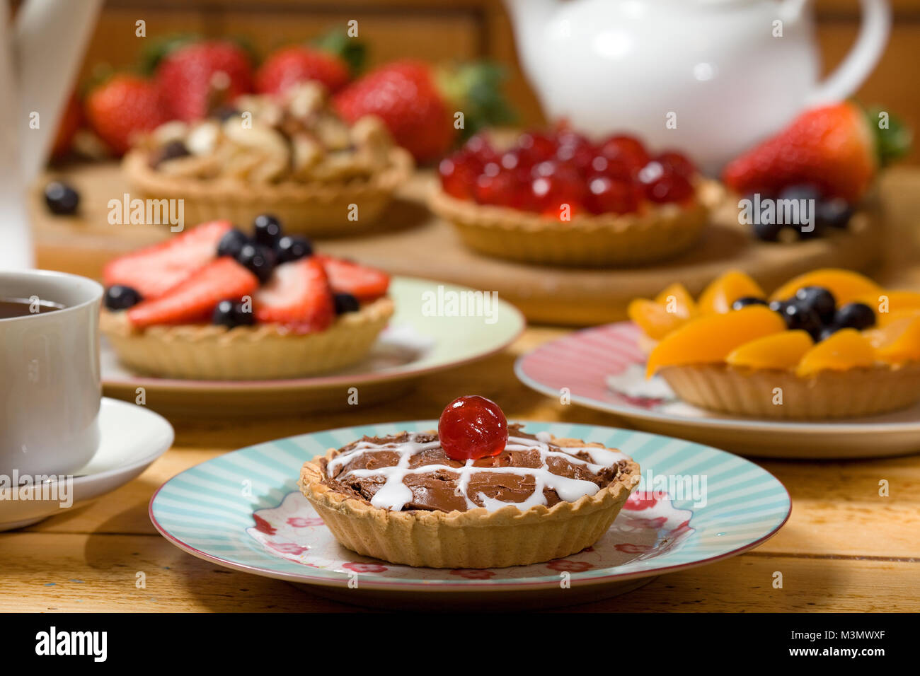 Schokoladentorte mit einer Auswahl von obstkuchen im Hintergrund Stockfoto