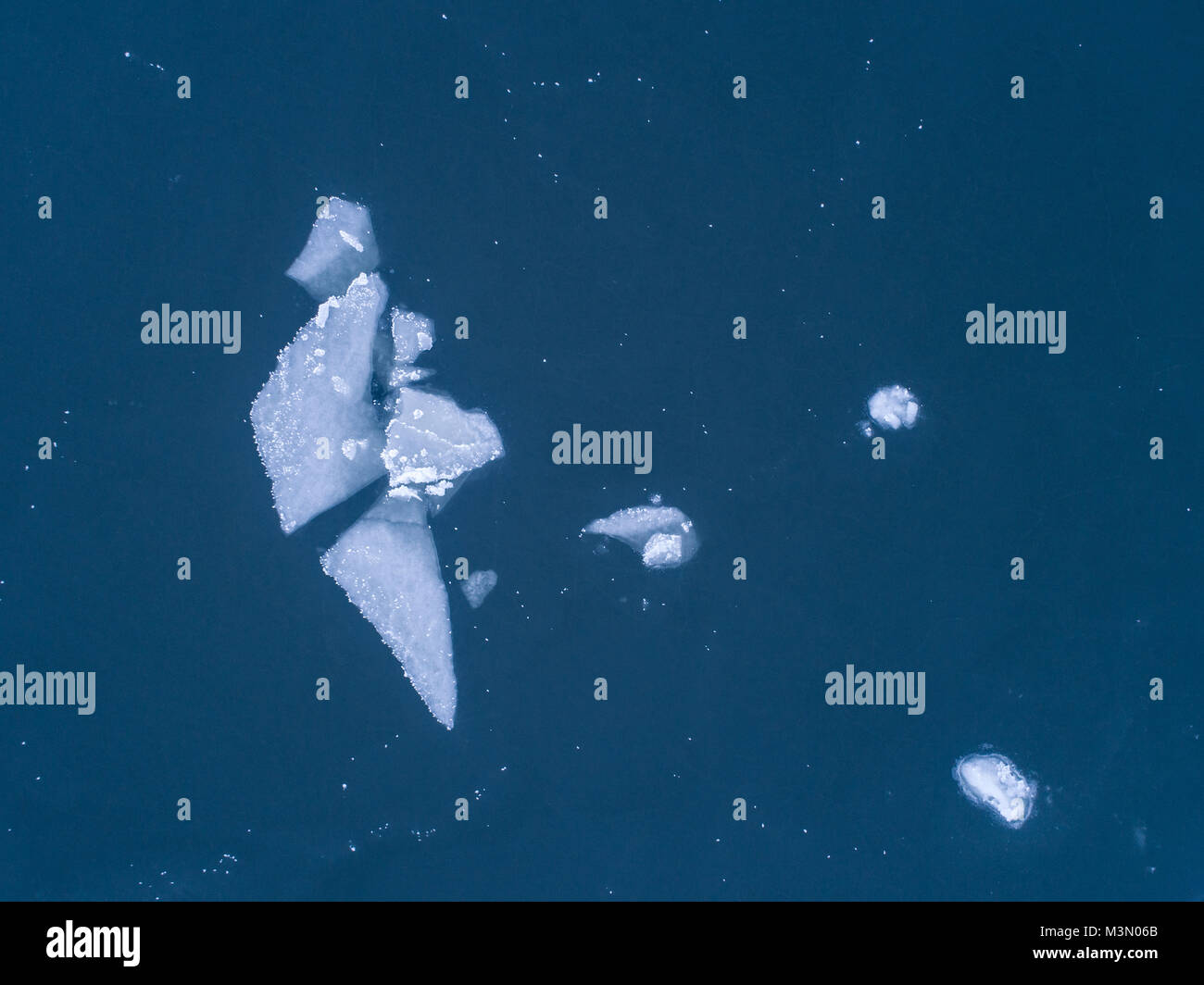 Vereinfachende Luftaufnahme von Eisbrocken schwimmend auf Meer gesehen direkt über Stockfoto