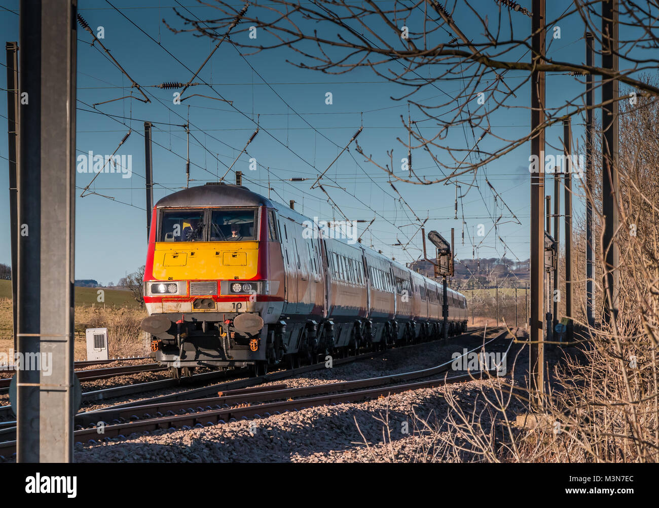 Ein southbound Jungfrau Bahn auf der East Coast Main Line in der Nähe von Alnmouth, Northumberland, North East England, an einem schönen Wintertag mit einem klaren blauen Himmel Stockfoto