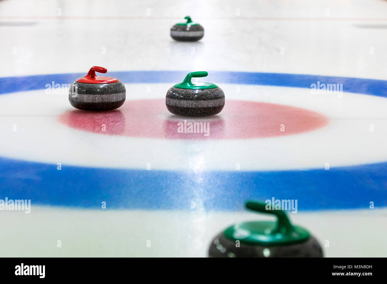 Curling Steine auf dem Eis Stockfoto