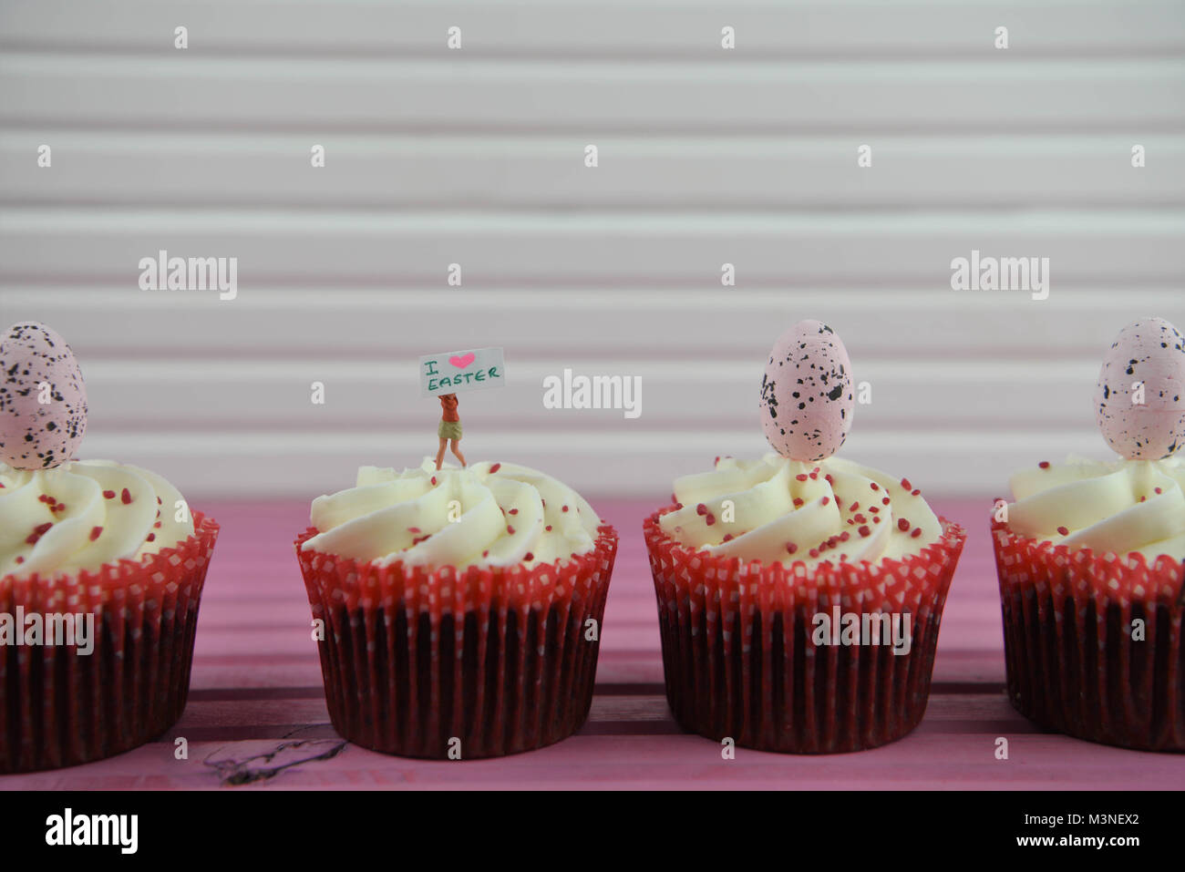 Ostern mit Cupcakes gekrönt mit Miniatur person Figur mit einem Schild für Ich liebe Ostern Stockfoto