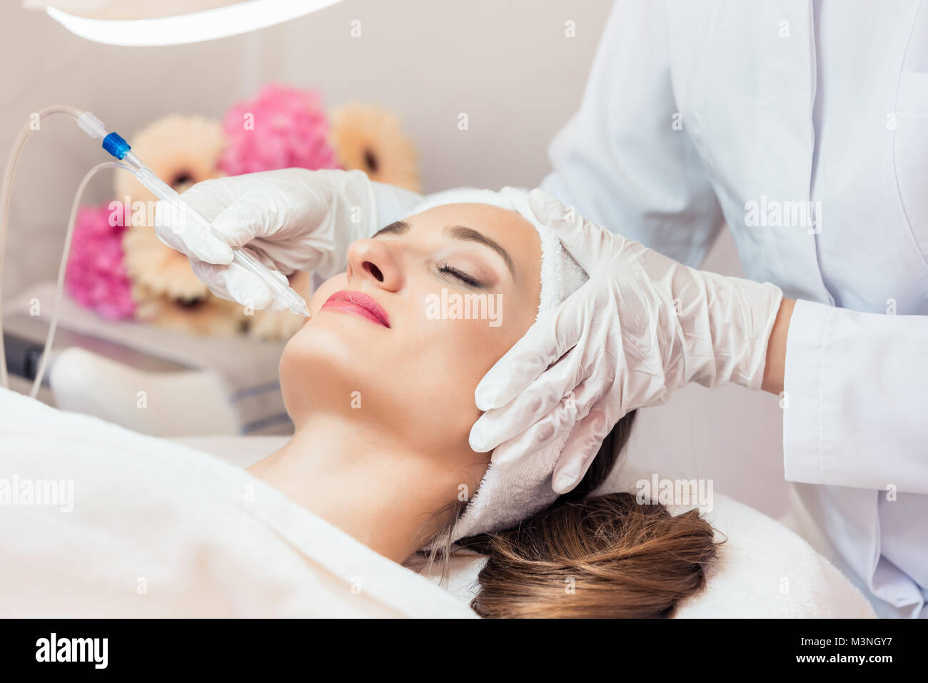 Schöne Frau Entspannung während nicht-invasive Gesichtsbehandlung für Verjüngung in ein modernes Beauty Center mit innovativer Ausstattung Stockfoto