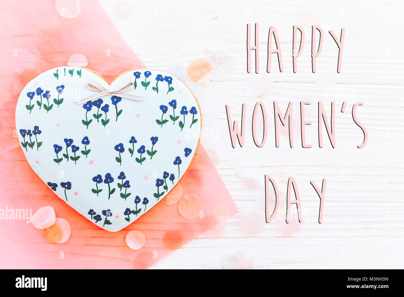 Der glückliche Frauen Tag Text zeichen Flach. 8. März. rosa Herzen Blumen und Konfetti auf weißen Holzmöbeln im Landhausstil Hintergrund. Platz für Text. Grußkarte conc Stockfoto
