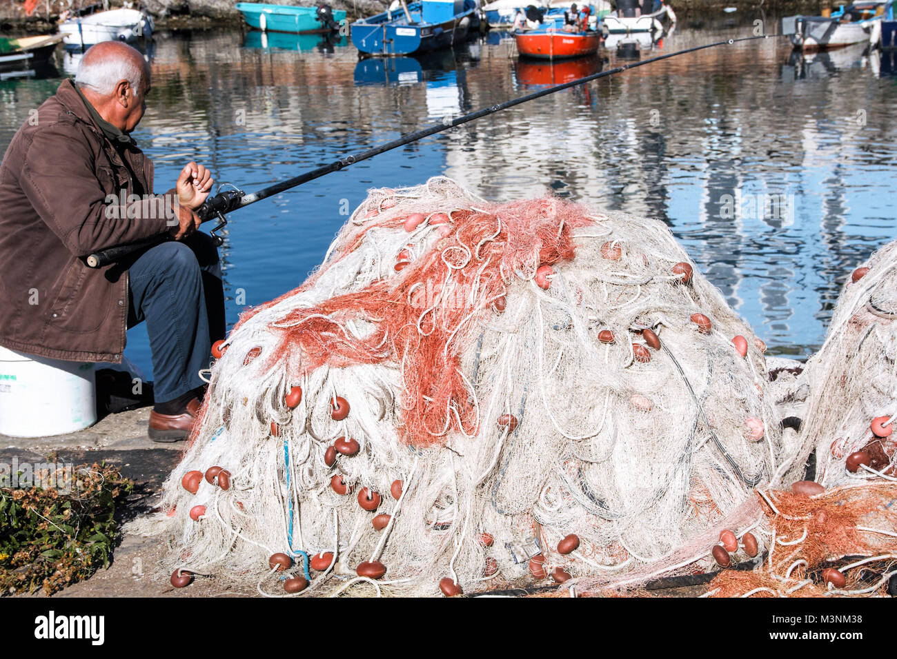 In Pozzuoli - Italien - Am 12/11/2016 - der alte Mann Fischerei mit einer Angel im Hafen Stockfoto