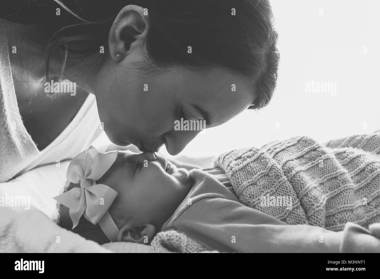 Junge Mutter küsste ihre adorable Baby Mädchen. Stockfoto