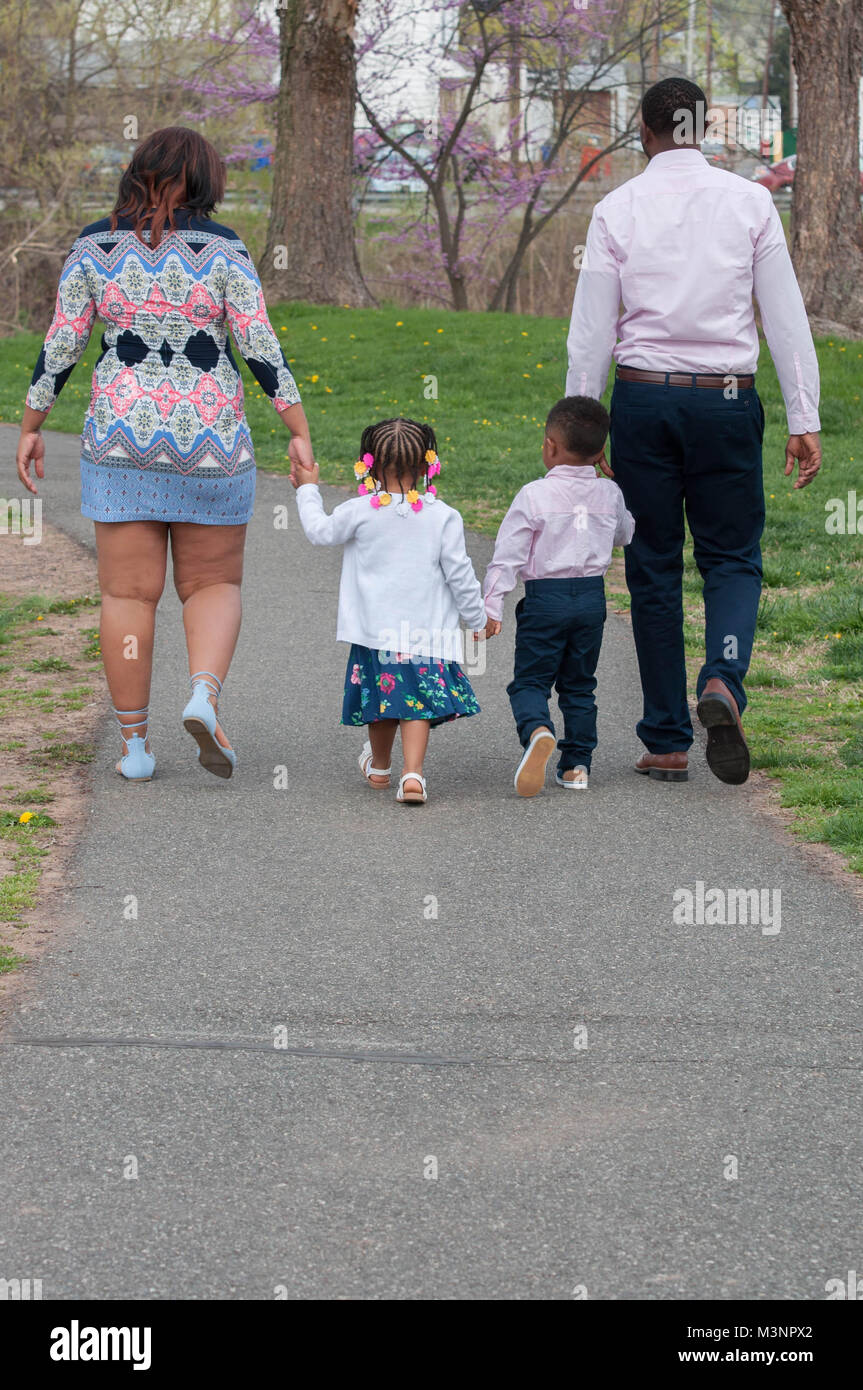 Familie halten sich an den Händen und Gehen durch einen Park Stockfoto
