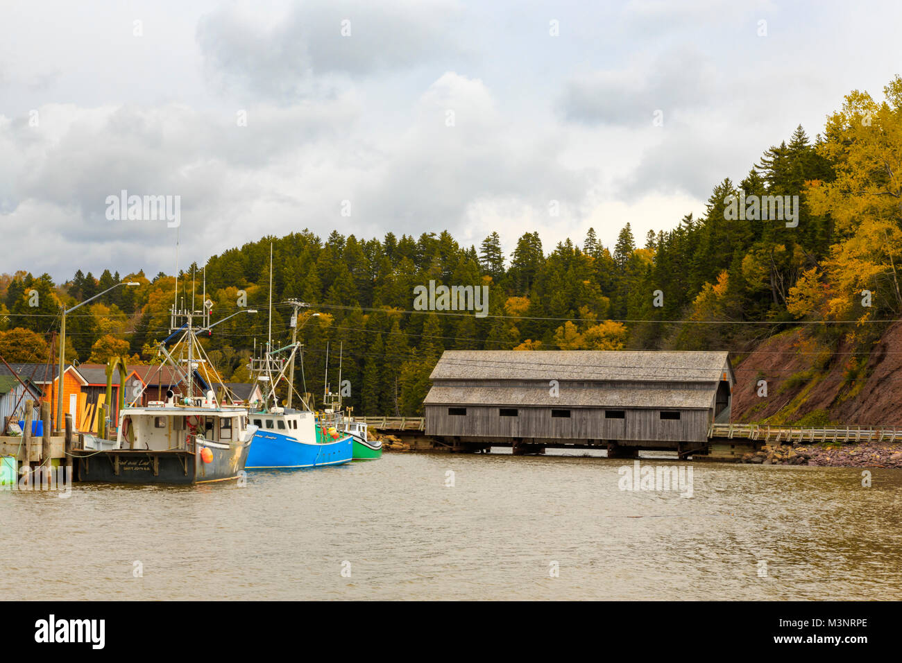 Schönen Herbst Blätter, kleine kommerzielle Fischerdorf, alte Brücke, alten bunten Fischerboote angedockt St Martins Bucht von Fundy New Brunswick Stockfoto