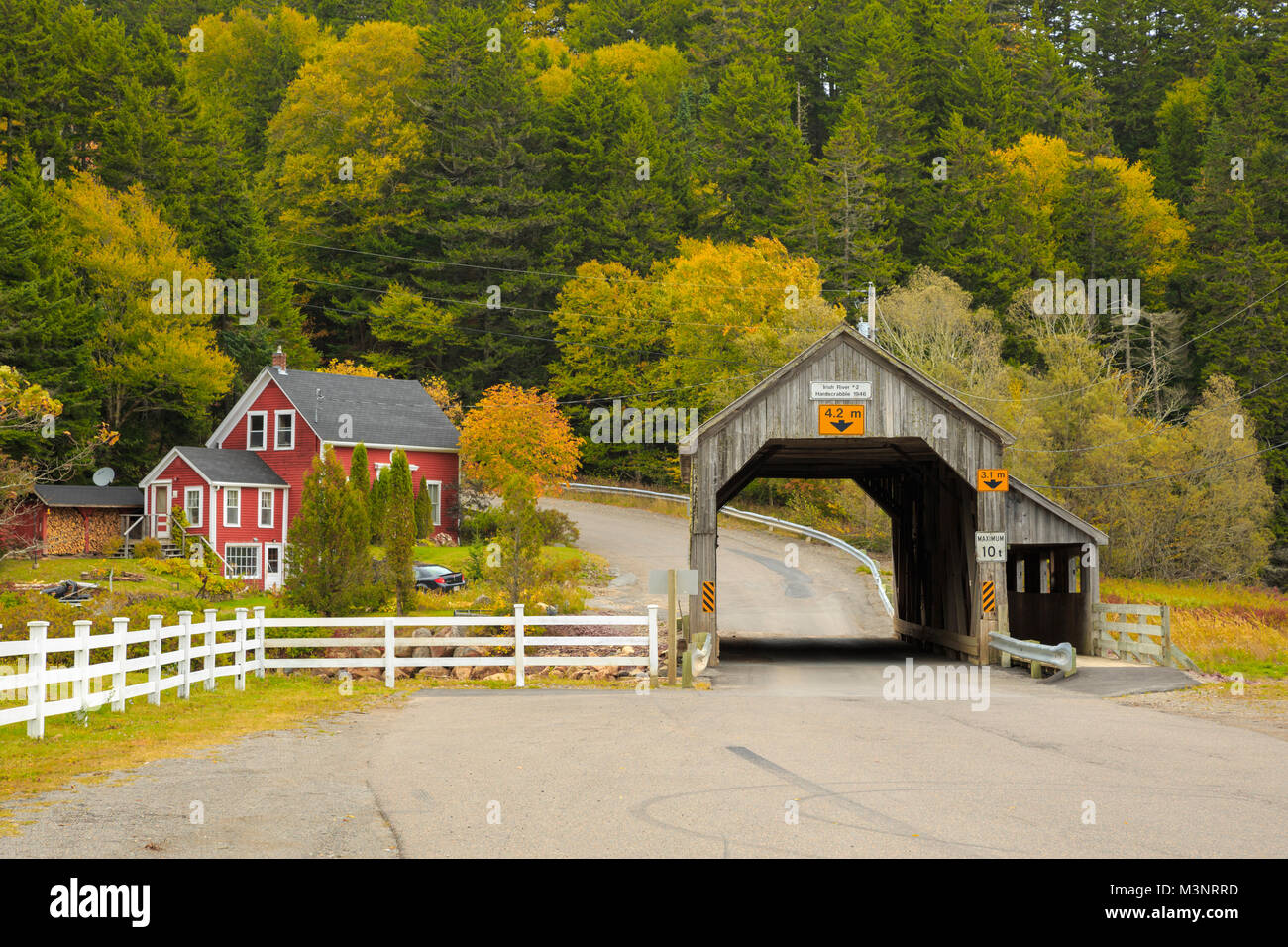 Malerische bunt Gelb Herbst Bäume umgeben alte hölzerne Brücke von ländlichen Red House St Martins Bucht von Fundy New Brunswick Kanada abgedeckt Stockfoto