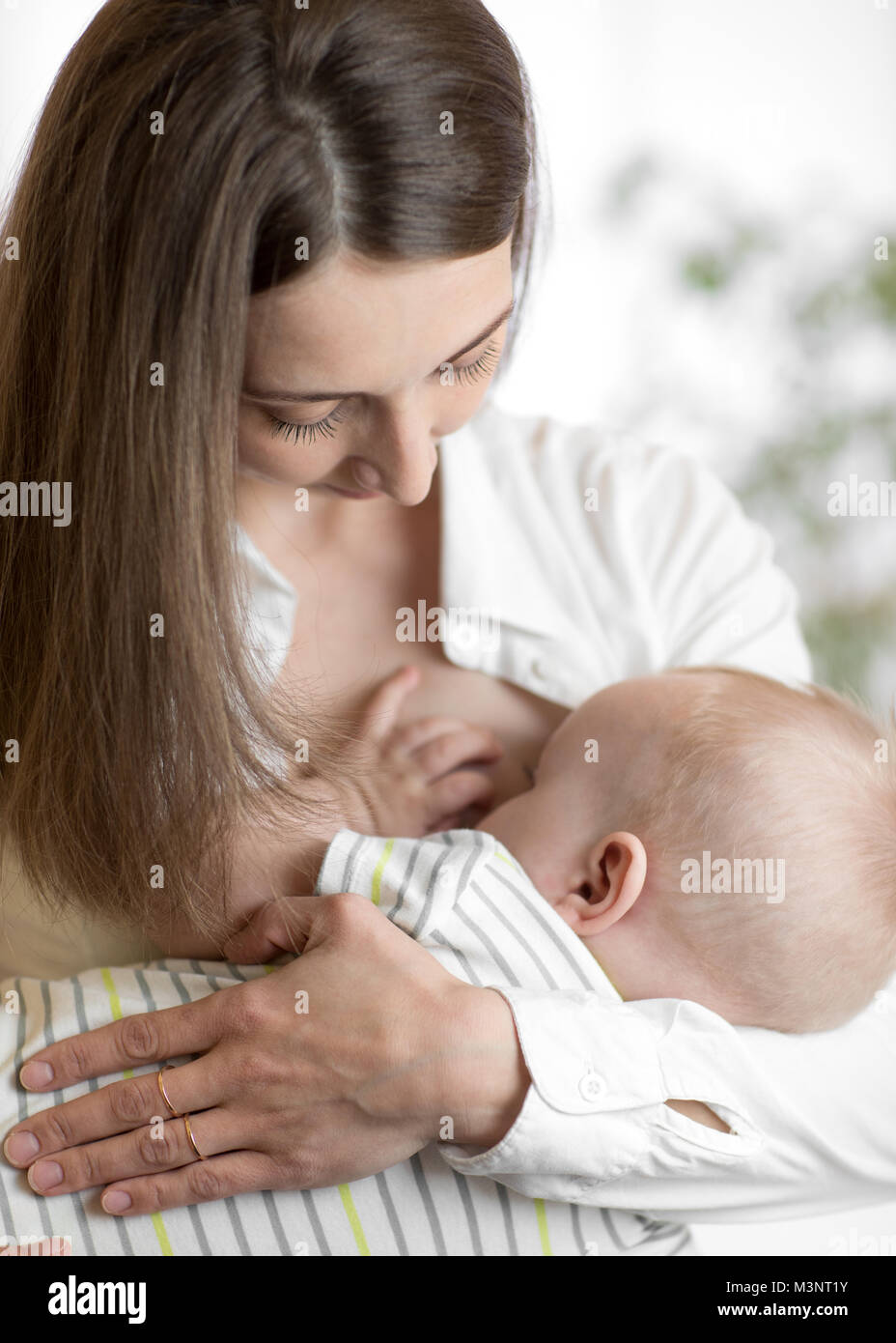 Junge Mutter ihr neugeborenes Kind halten. Mama Pflege Baby. Hübsche Frau stillen Kid. Stockfoto