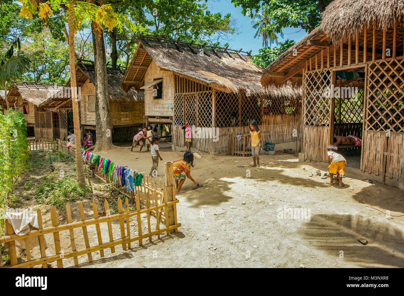 Junge Mangyanen Vorschulalter spielen improvisierten Spiele im Freien zusammen außerhalb ihres Bambus nipa Wohnungen im Aninuan, Oriental Mindoro, Philippinen. Stockfoto
