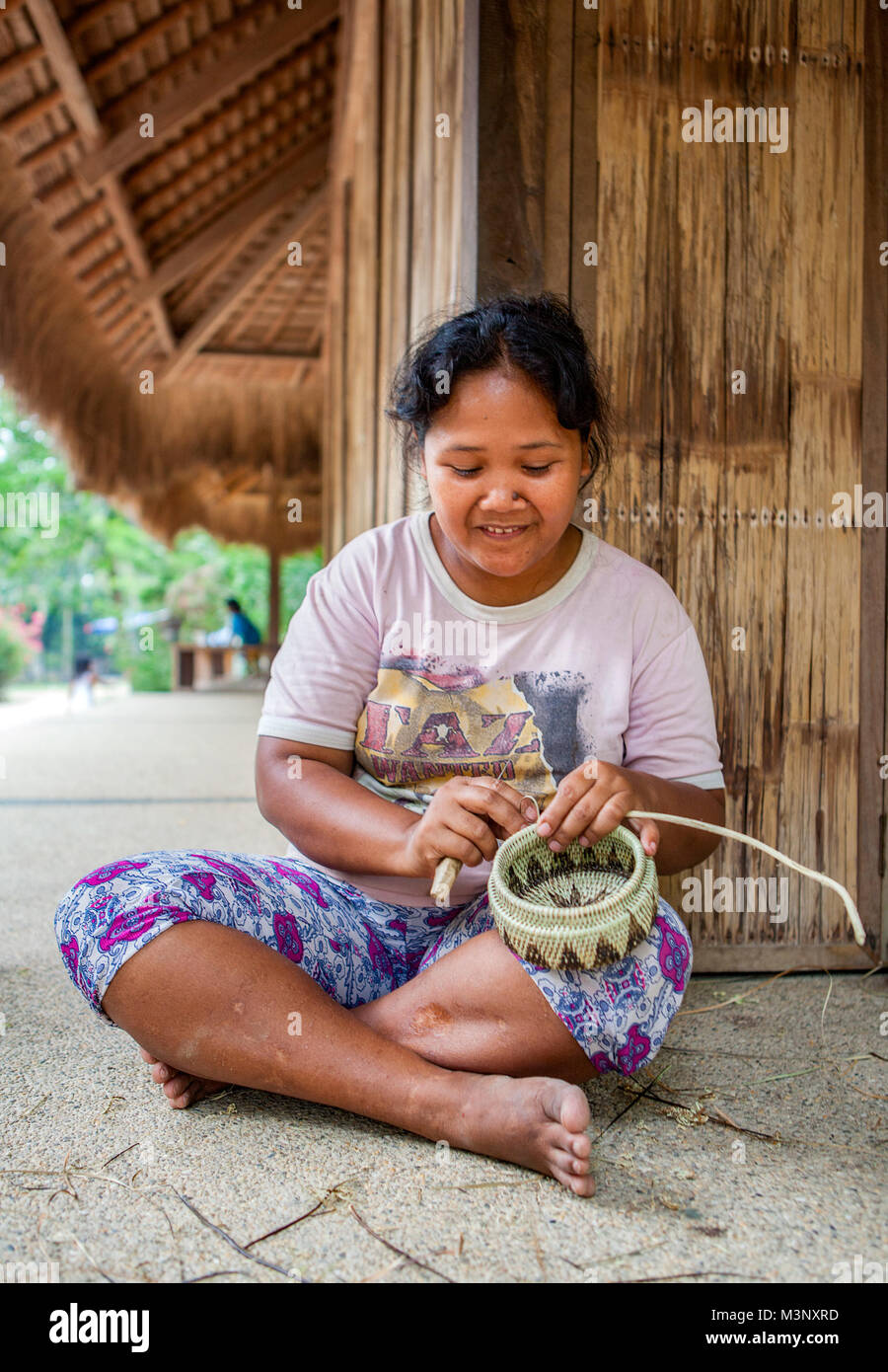 Aninuan, Oriental Mindoro, Philippinen - ein mangyanen Handwerkerin webt einen Korb in ihrem Dorf Sitio talipanan in Oriental Mindoro, Philippinen. Stockfoto