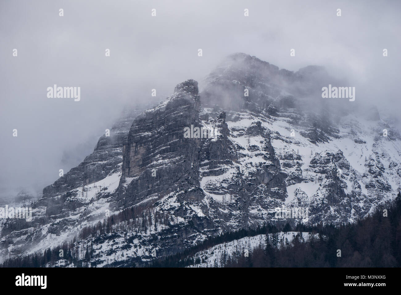 Imposante Landschaft in den österreichischen Alpen mit hoch aufragenden Klippen in Wolken und Nebel verschlungen Stockfoto