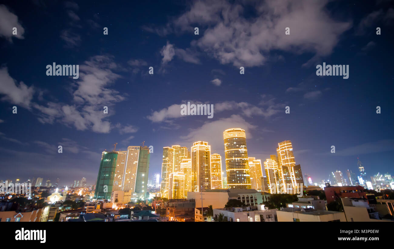 Zeitrafferaufnahme der Wolkenkratzer in Manila Makati City. Skyline bei Nacht, Philippinen. Stockfoto