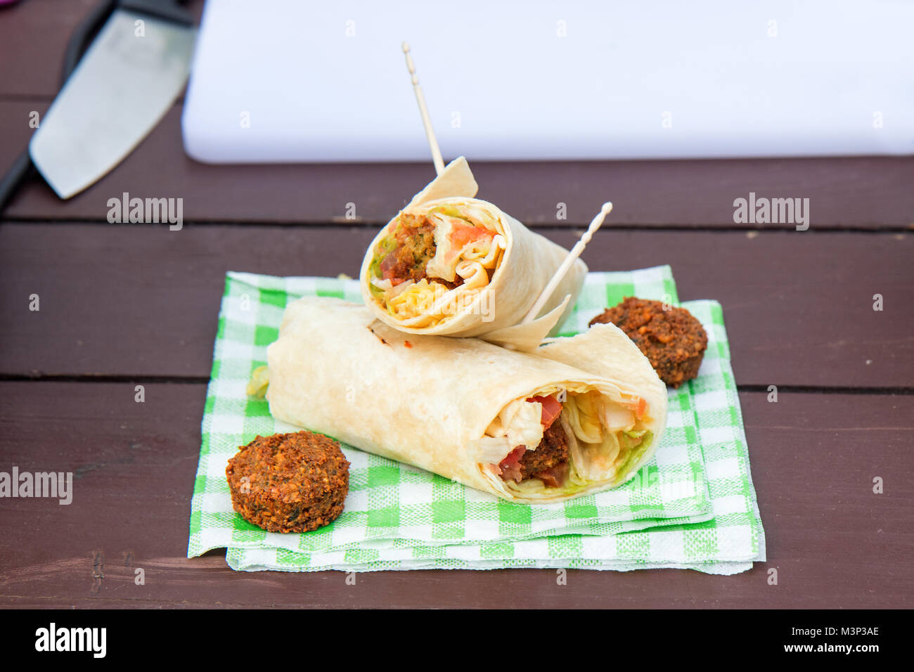 Der Straße Essen, vegetarische Gemüse wrap serviert auf dem Papier Serviette. Die grüne letuce, Tomaten, Zwiebeln und 2 Stück von kichererbsen Falafel. Stockfoto