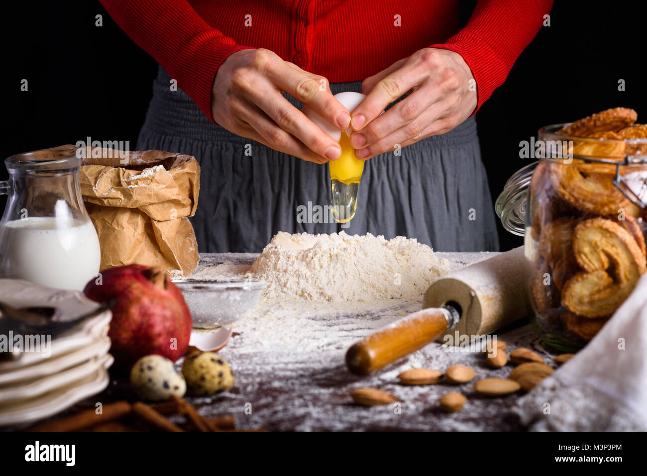 7/8 Schuß von person Kochen Teig bei Tisch mit Zutaten Stockfoto