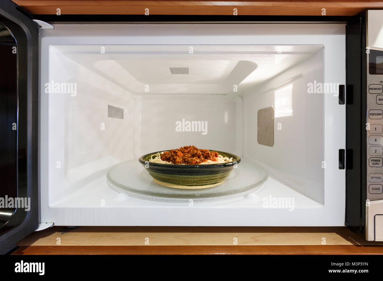 Küche Haushaltsgeräte kochen Nacherwärmung Teller Schüssel Schüssel Mahlzeit Abendessen mit gekochten spaghetti Nudeln mit Bolognese Tomate Soße in Mikrowelle Stockfoto