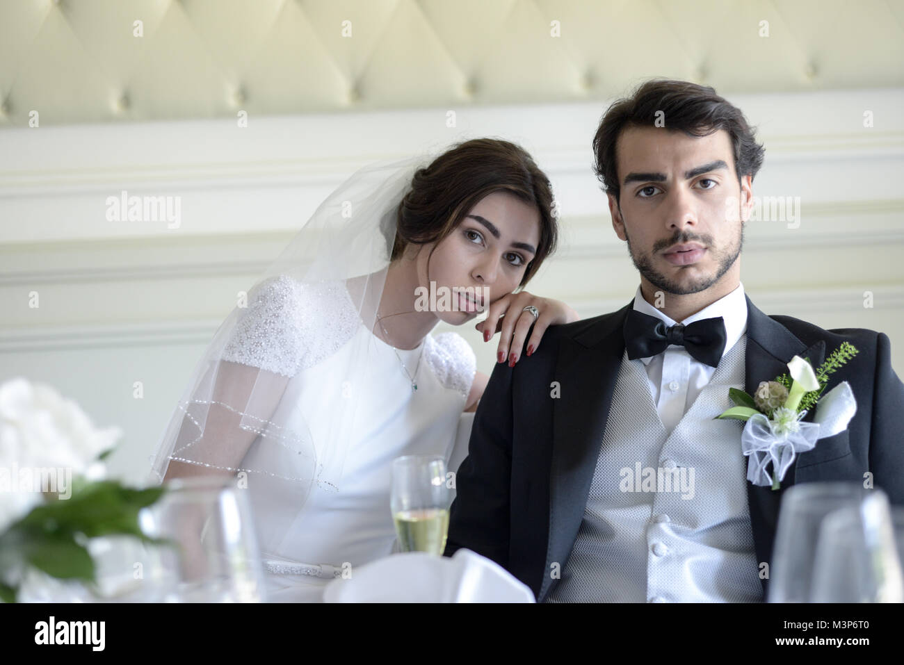 Schöne dunkelhaarige Braut und Bräutigam auf eine gestaltete Hochzeitstag - traditionelles weißes Kleid/schwarzen Anzug - Art déco-Stil mit hellen, sonnigen Tag Stockfoto