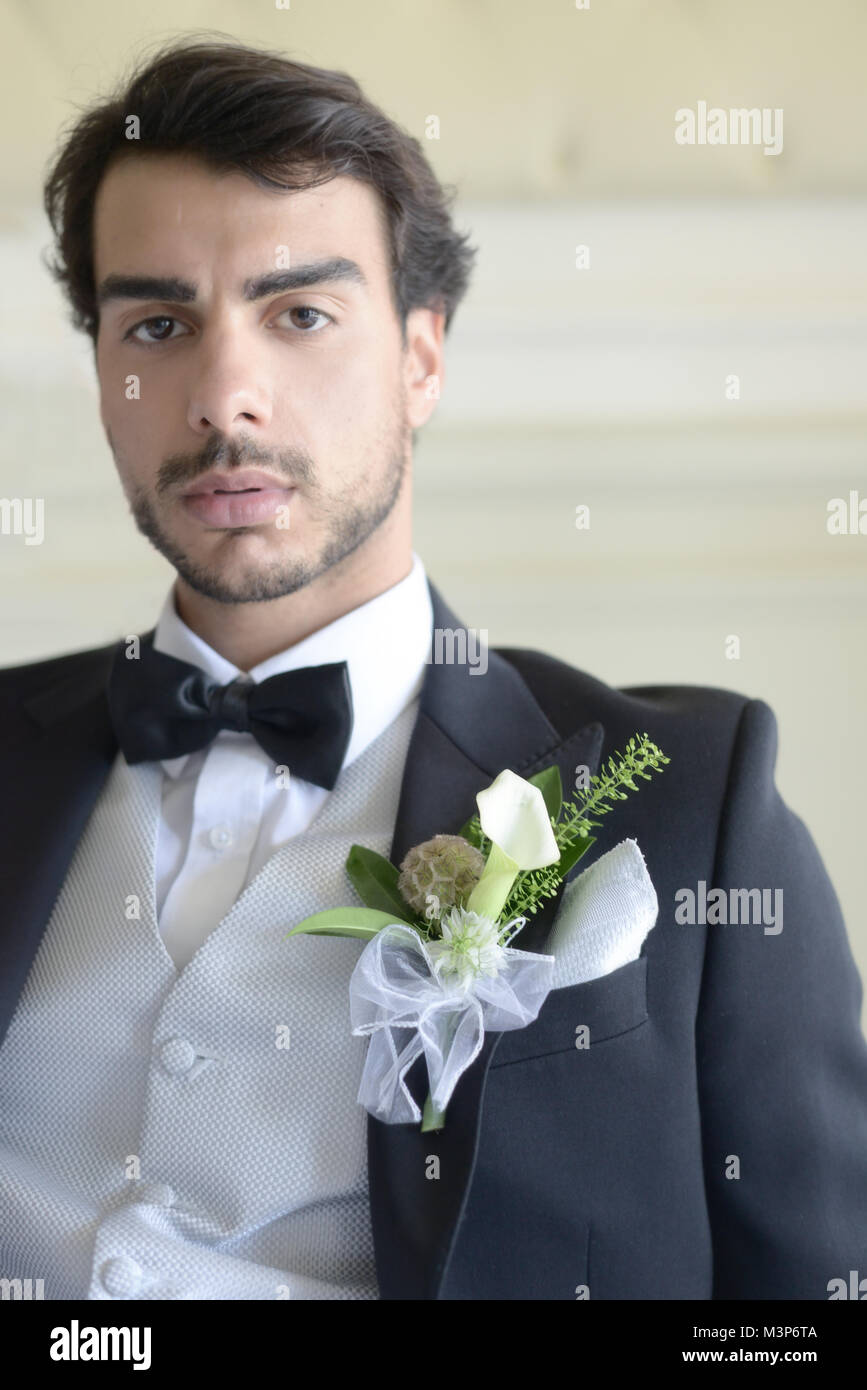 Porträt einer hübschen dunkelhaarigen jungen Mann Hochzeit Kleidung auf einem hellen, sonnigen Tag, blickt er zuversichtlich und fröhlich Stockfoto
