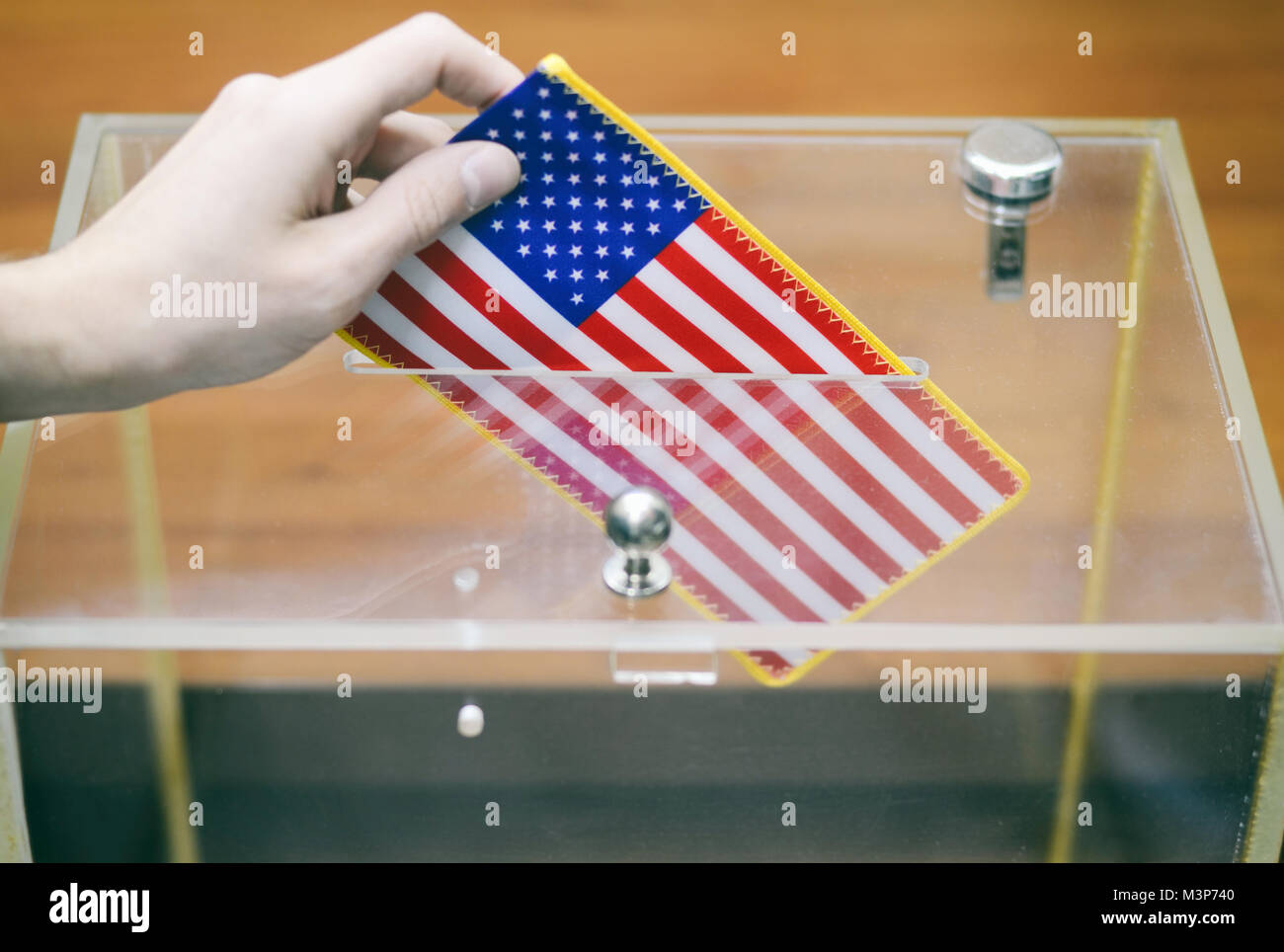 Mann einfügen Flagge der Vereinigten Staaten von Amerika in die Wahlurne, Abstimmungen und Wahlen in den Vereinigten Staaten von Amerika. Stockfoto