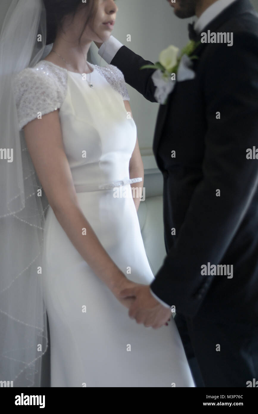Schöne dunkelhaarige Braut und Bräutigam auf eine gestaltete Hochzeitstag - traditionelles weißes Kleid/schwarzen Anzug - Art déco-Stil mit hellen, sonnigen Tag Stockfoto
