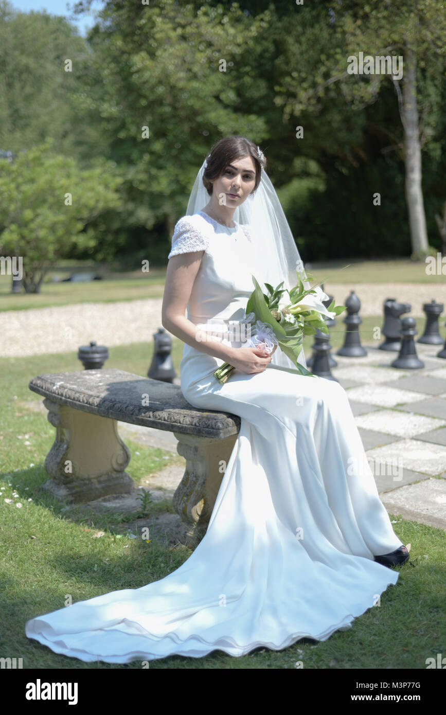 Eine schöne dunkelhaarige Braut tragen eine teure Hochzeit Kleid an einem sonnigen Tag - Hell Stockfoto