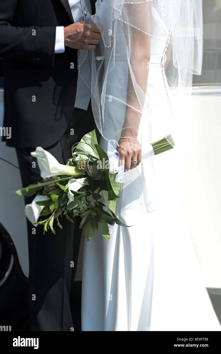 Schöne dunkelhaarige Braut und Bräutigam auf eine gestaltete Hochzeitstag - traditionelles weißes Kleid/schwarzen Anzug - Art déco-Stil mit hellen, sonnigen Tag Stockfoto