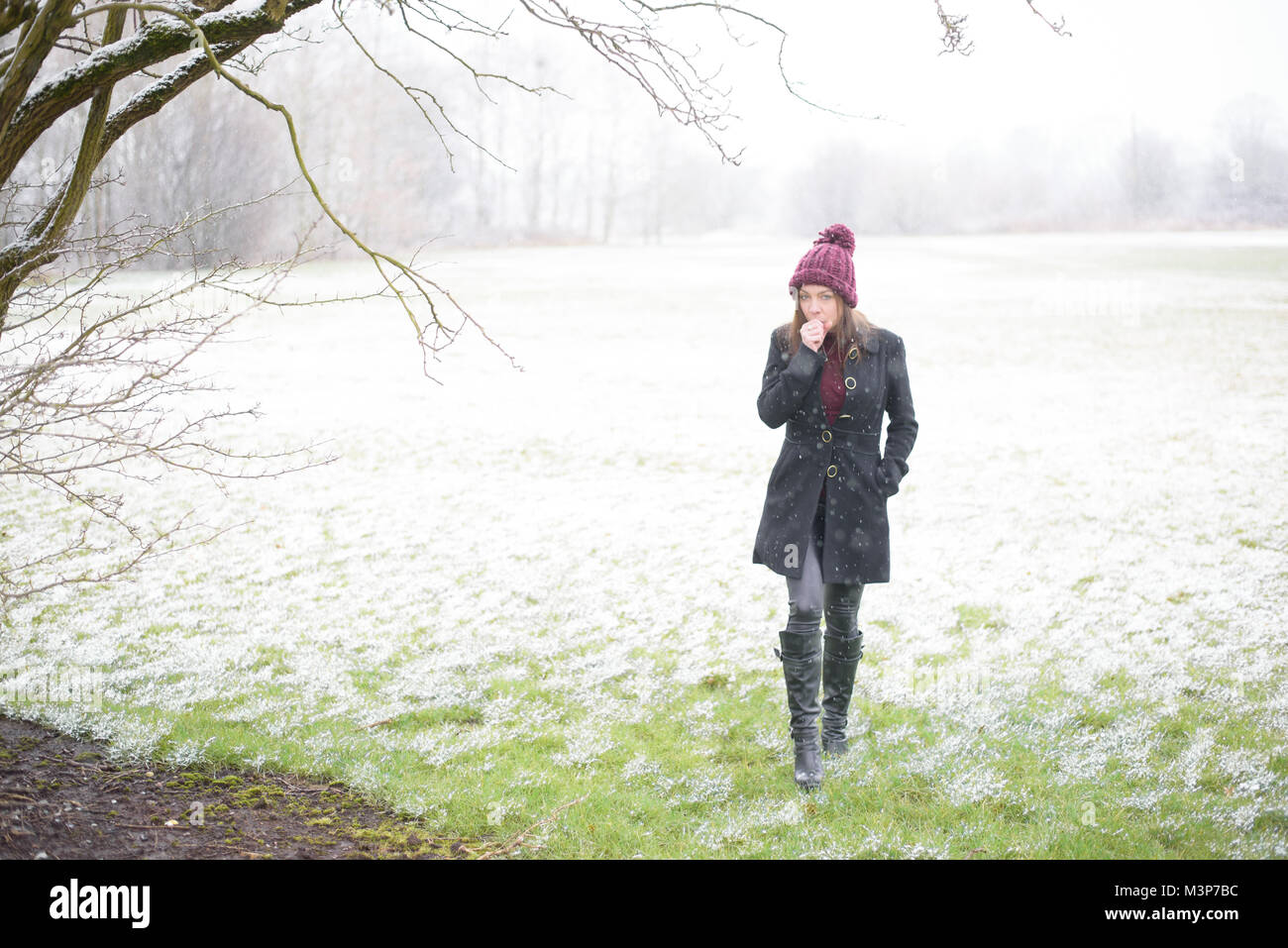 Lady wandern durch verschneite Feld Stockfoto