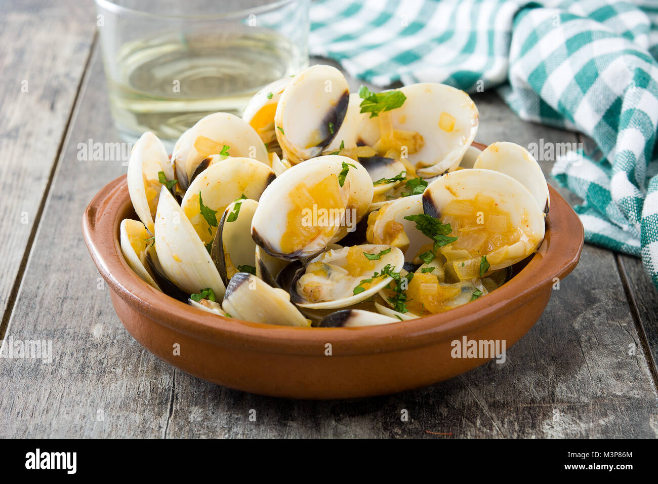 Marinera Venusmuscheln mit Sauce. Almejas a la Marinera. Spanisch Rezept auf  hölzernen Tisch Stockfotografie - Alamy