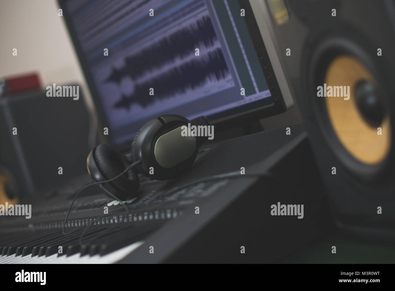 Professionelle Monitore, Kopfhörer, midid Tastatur und PC mit Musik Software. Stockfoto