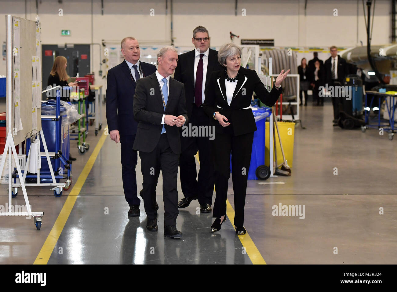 Premierminister Theresa May spricht mit Michael Ryan (Zweite links), President von Bombardier Flugzeugstrukturen und Engineering Services Division, bei einem Besuch der Bombardier Werk in Belfast vor dem Treffen der wichtigsten politischen Parteien in Stormont, für Gespräche, die auf ein Ende der 13-monatigen politischen Stillstand. Stockfoto