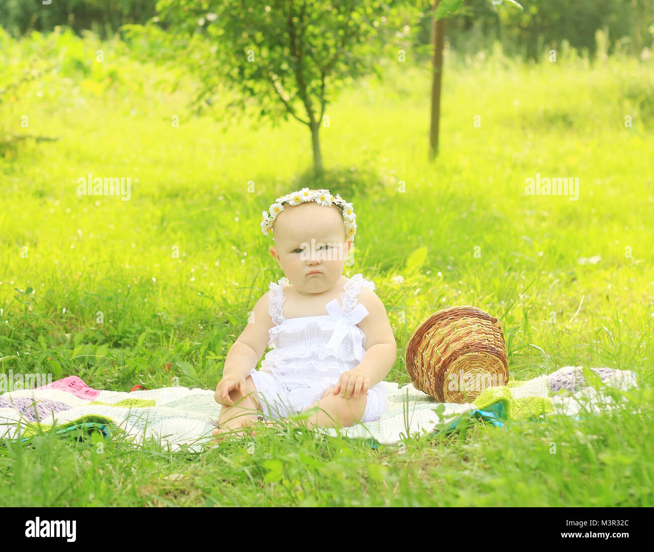 Cute Baby in einen Kranz auf ein Picknick auf einem Sommertag. Stockfoto