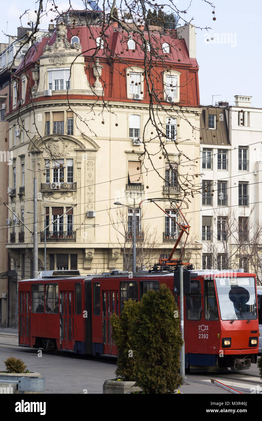 Ein Gebäude mit rotem Dach und eine alte rote Straßenbahn in Belgrad, Serbien. Stockfoto