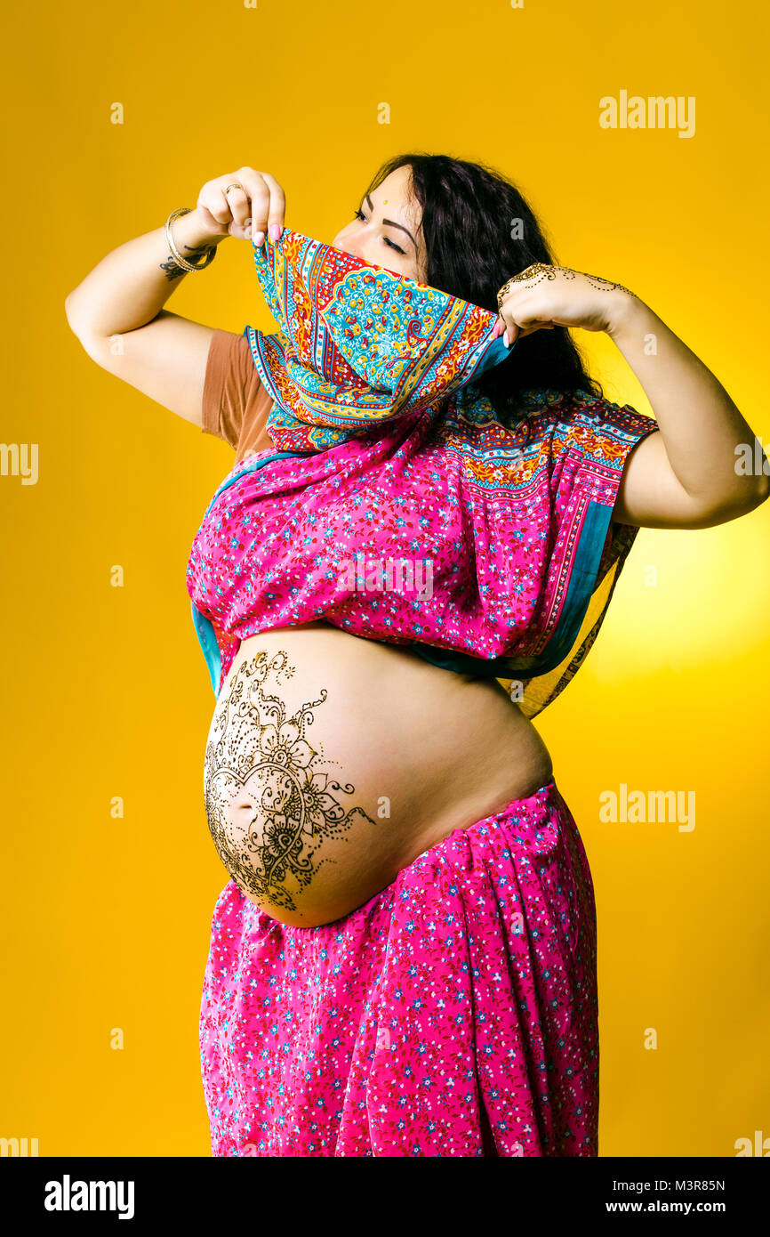 Gerne schwangere Frau in der indischen Sari, Bauch und Hände mit Henna bemalt Stockfoto