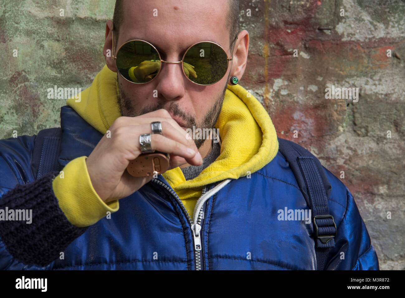 Porträt eines jungen Mannes in einem blauen Jcket mit gelben Haube Stockfoto