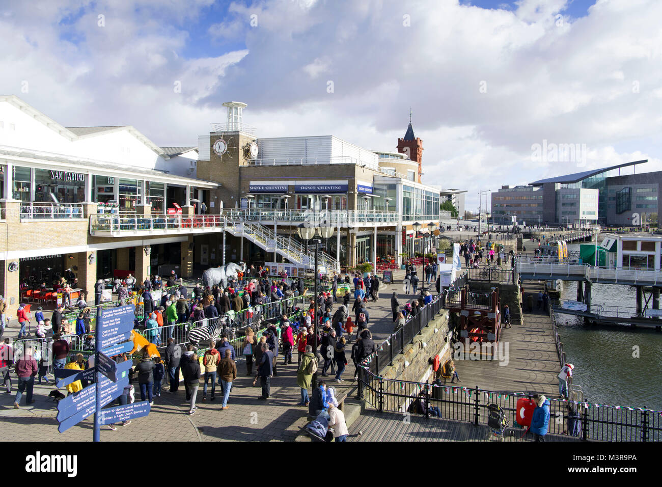 Eine allgemeine Ansicht der Mermaid Quay in Cardiff Bay an einem warmen sonnigen Tag mit blauen Himmel in Cardiff, South Wales, UK. Stockfoto