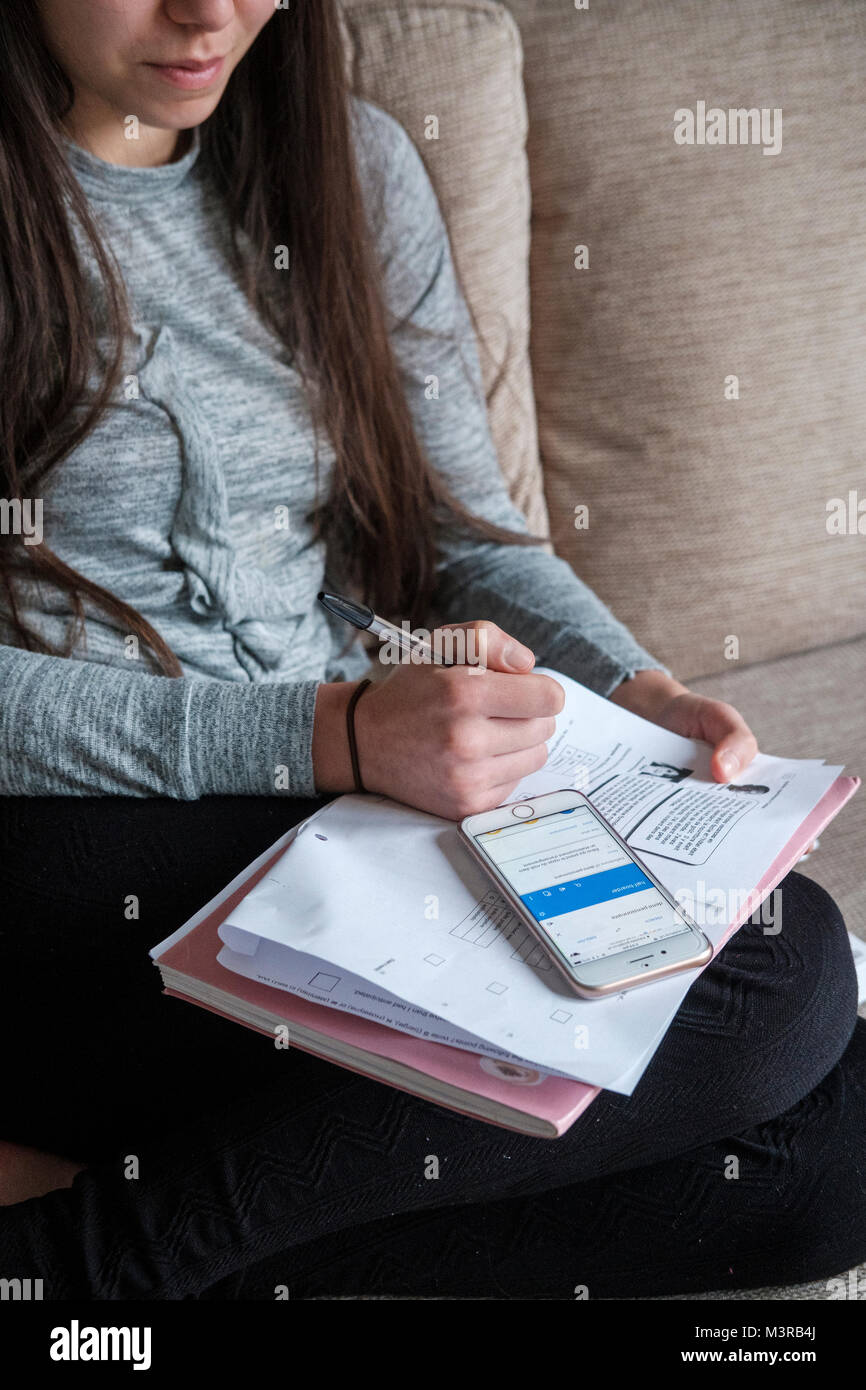 Junges Mädchen arbeitet auf ihre Hausaufgaben verwendet Google auf Ihrem Smartphone, Surrey, Großbritannien Stockfoto