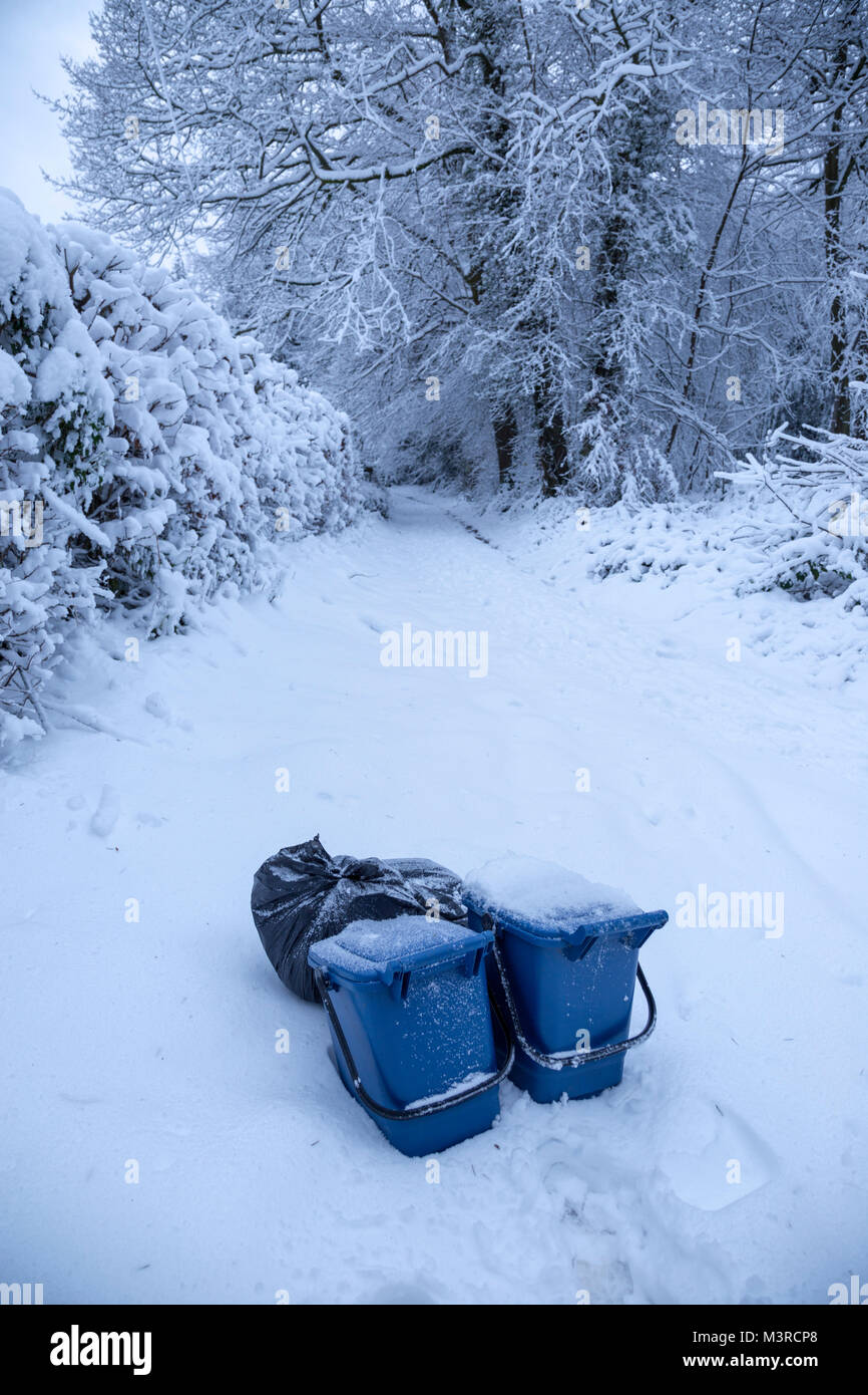 Kunststoff blau Essen Abfallbehälter wartet Sammlung auf einer schmalen Landstraße in Monmouthshire nachts Schneefall. Stockfoto