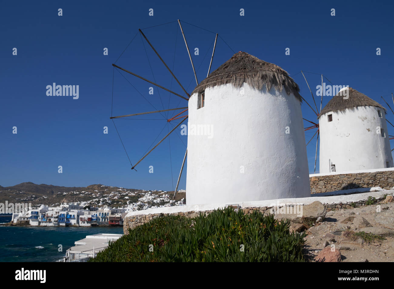 Iconic Windmühlen mit Blick auf die Stadt Mykonos (Chora), Kykladen, Ägäis, Griechenland. Stockfoto