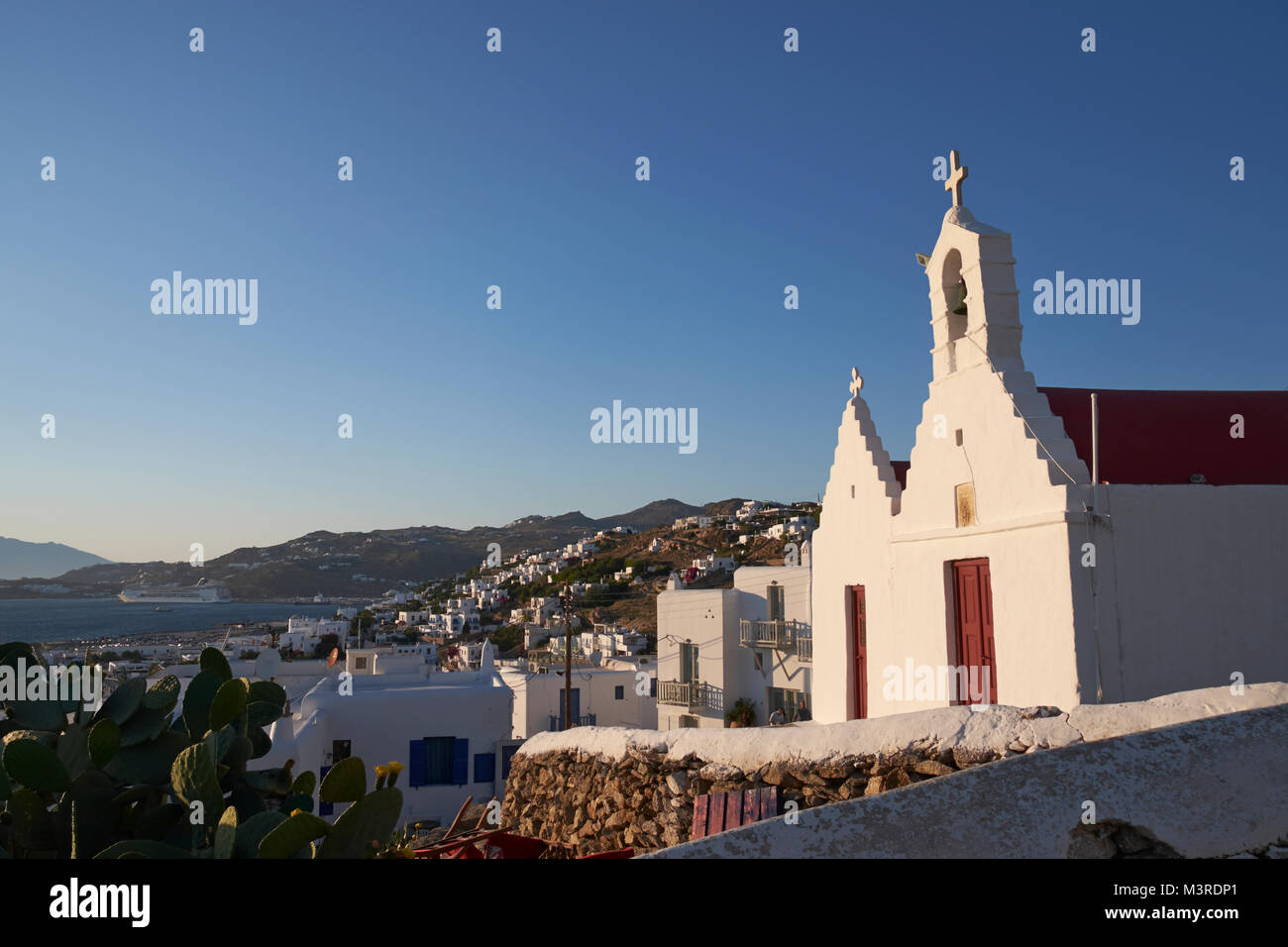 Eine kleine Kirche mit Blick auf die Stadt Mykonos, Kykladen, Ägäis, Griechenland. Stockfoto