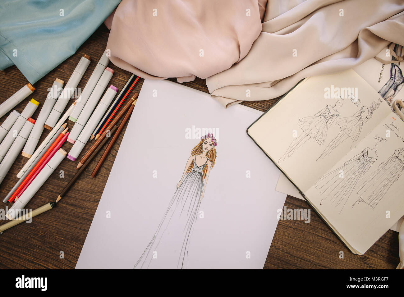 Fashion design Skizzen, Kleid Materialien und Stifte auf dem Tisch. Fashion Design Zubehör auf einen Tisch. Stockfoto