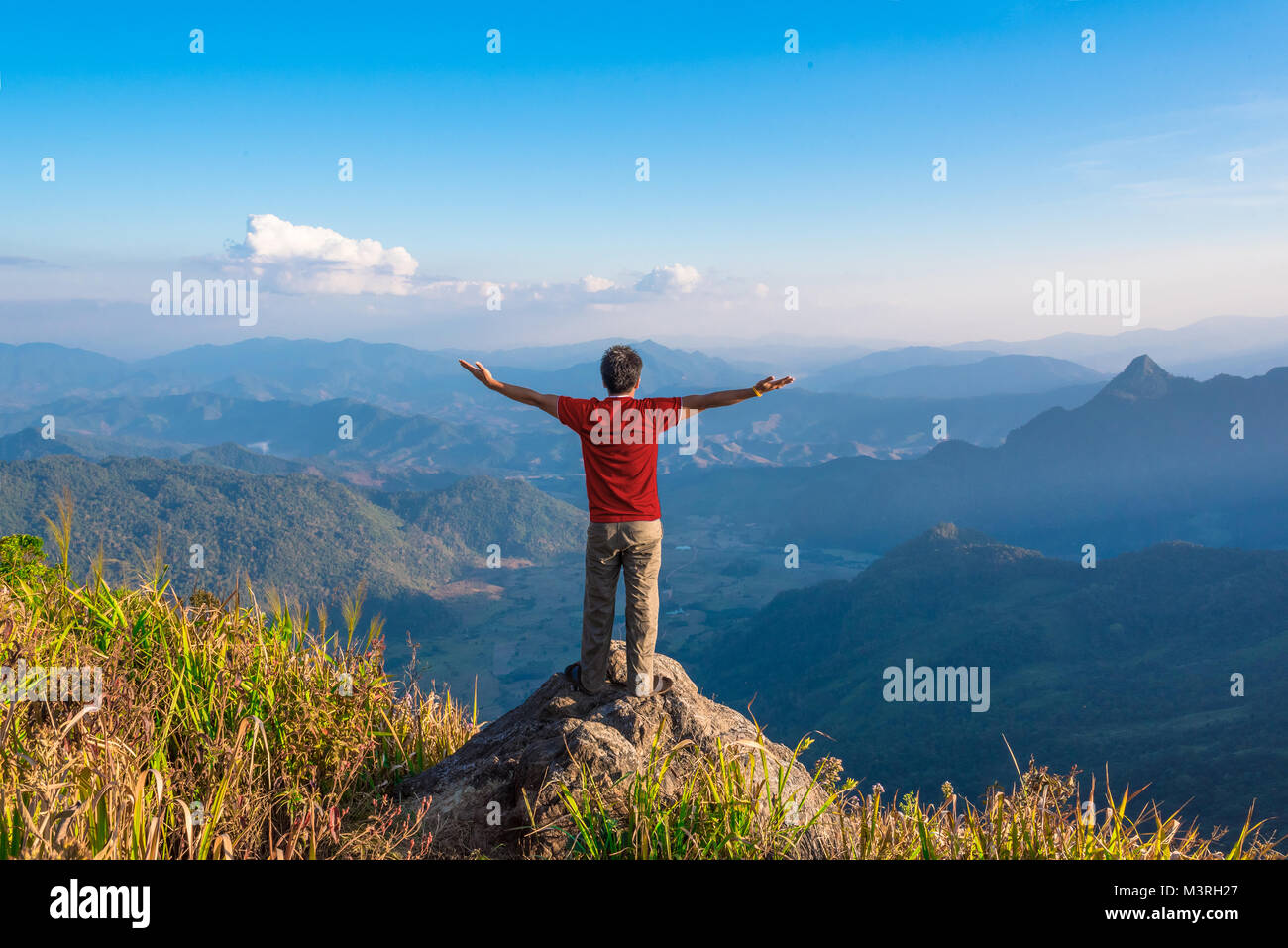 Männliche Hipster Traveler stand auf dem Stein mit wunderschönen Berglandschaft im Hintergrund, Abenteuer, Reisen, touristische Konzept Stockfoto