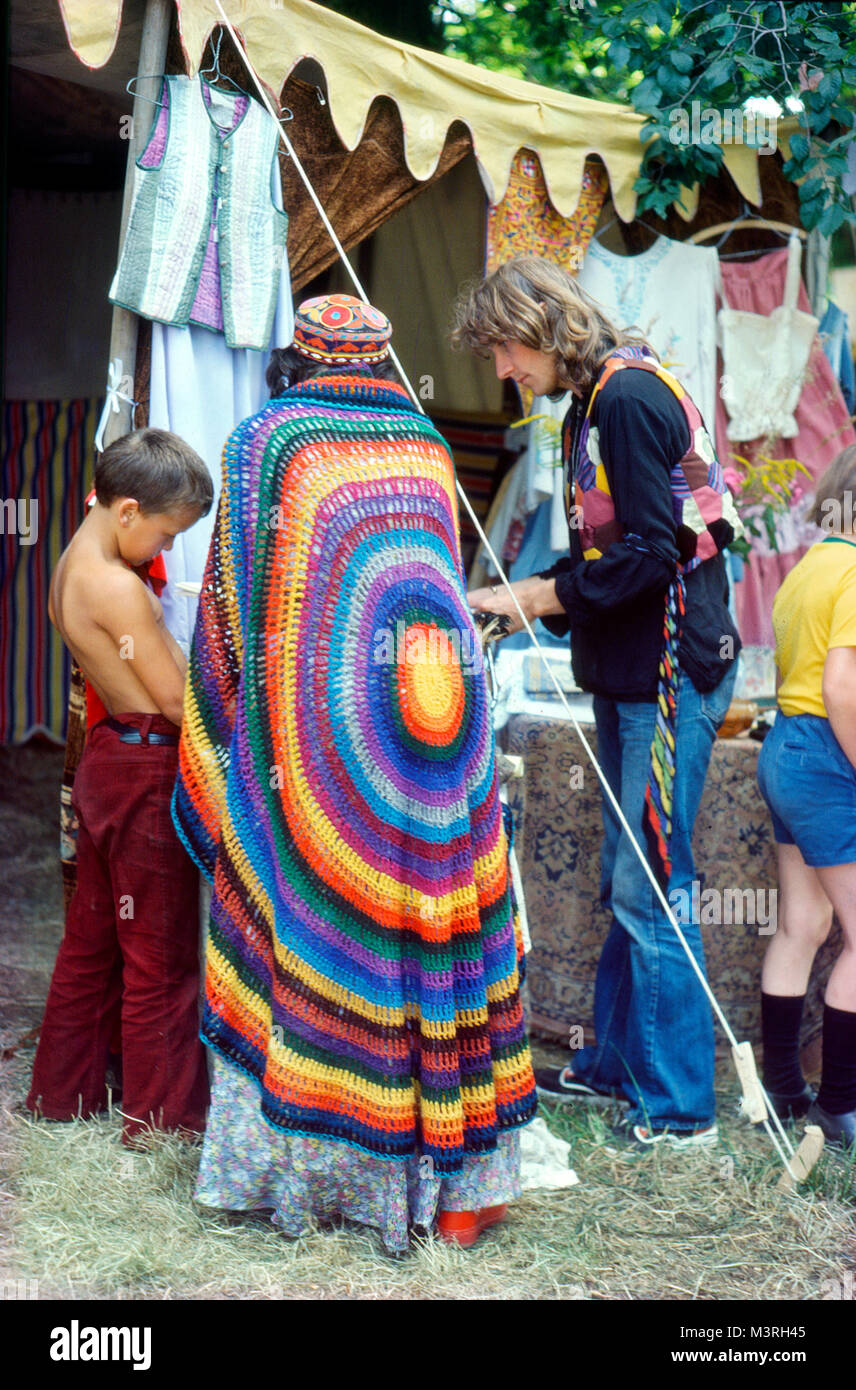 Frau in einem farbenfrohen Regenbogen-Häkeltuch, die Kunsthandwerk in einem Stallladen beim Barsham Fair Medieval Music Festival 1974 in Beccles Suffolk England 70s 1970s KATHY DEWITT ansieht Stockfoto