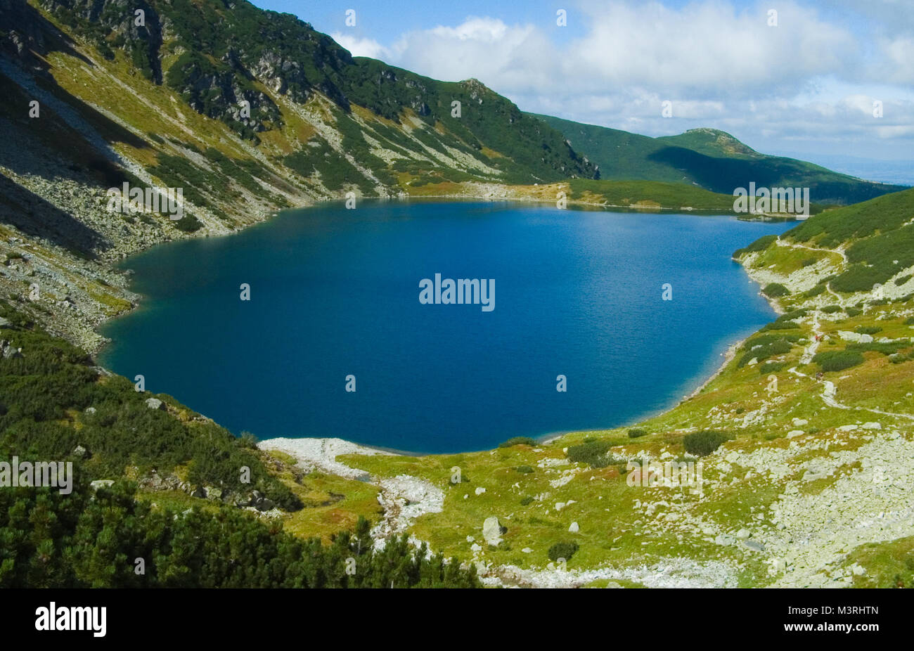 Polnisch Tatry Tatra, kristallklarem Wasser See/Teich im Tal an sonnigen Herbsttag. Wasser Reflexionen, Berg und Himmel spiegeln. Stockfoto