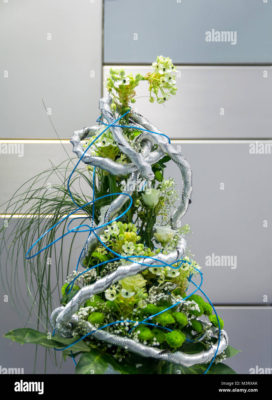 Blumenschmuck vor verschiedenen Stahlpaneele mit verschiedenen Oberflächen Stockfoto
