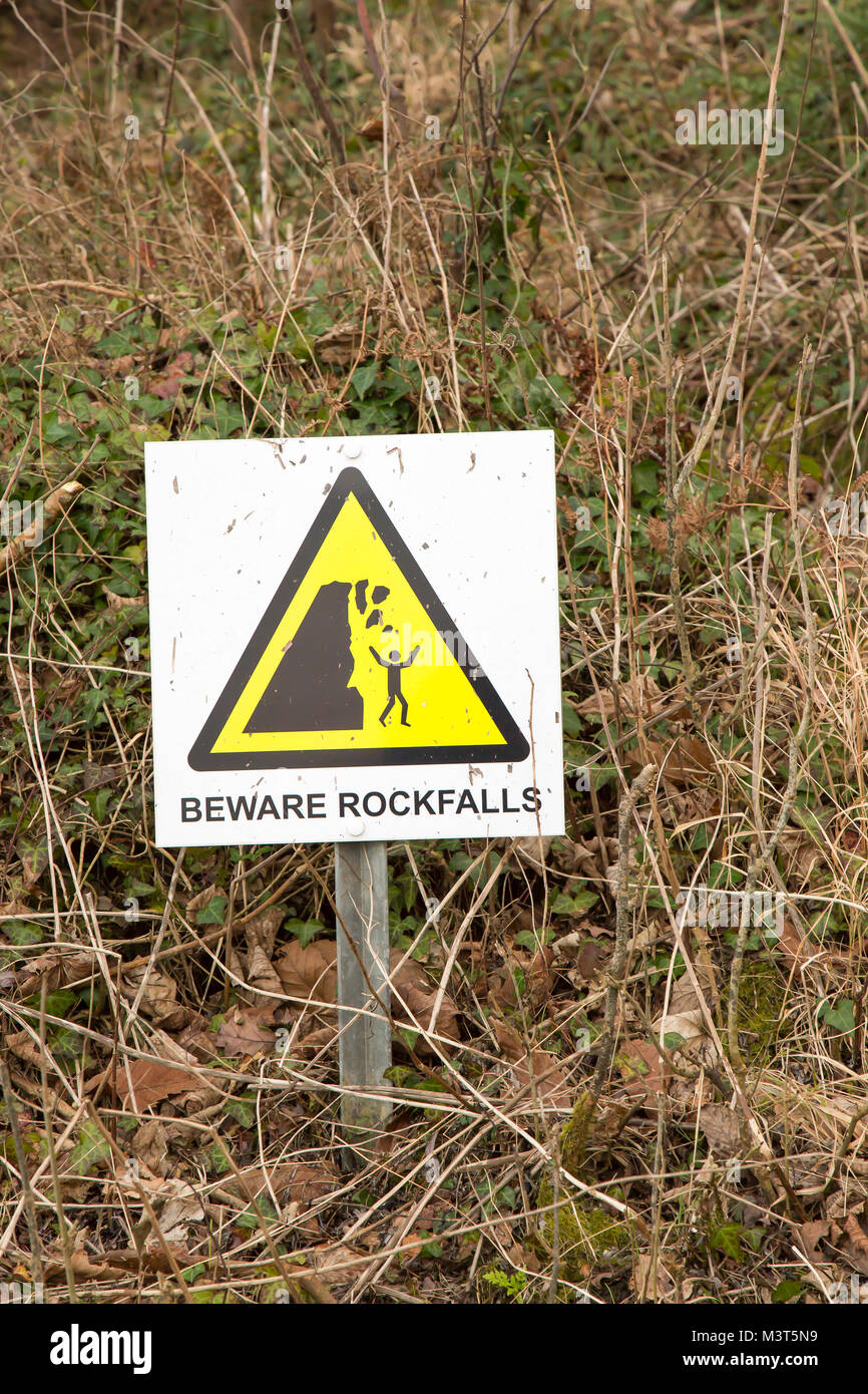 Schild „Vorsicht vor den Rockfalls“ auf dem South Beach Studland unter den zerklüfteten Klippen an der Dorset-Küste. Gesundheits- und Sicherheitshinweis für die Öffentlichkeit. Stockfoto