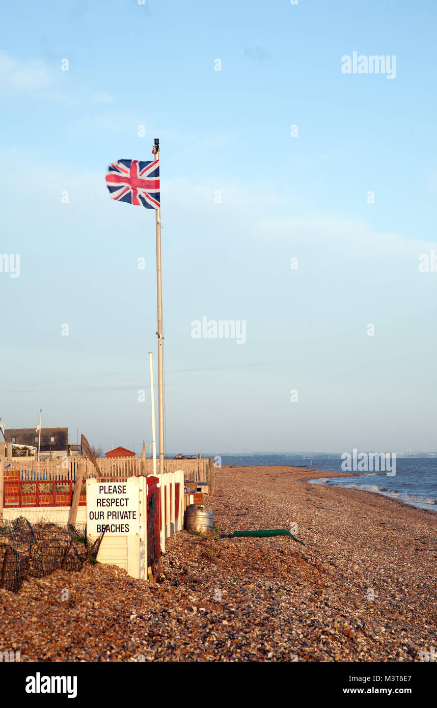 Union Flag über einen Privatstrand am Seasalter, Whitstable, Kent, Großbritannien fliegen, an einem windigen Tag. Stockfoto