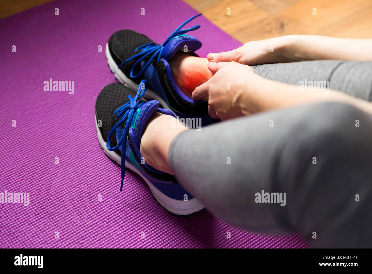 Junge Frau mit einer Knöchelverletzung beim Trainieren. Sport Übung Verletzungen Konzept. Stockfoto