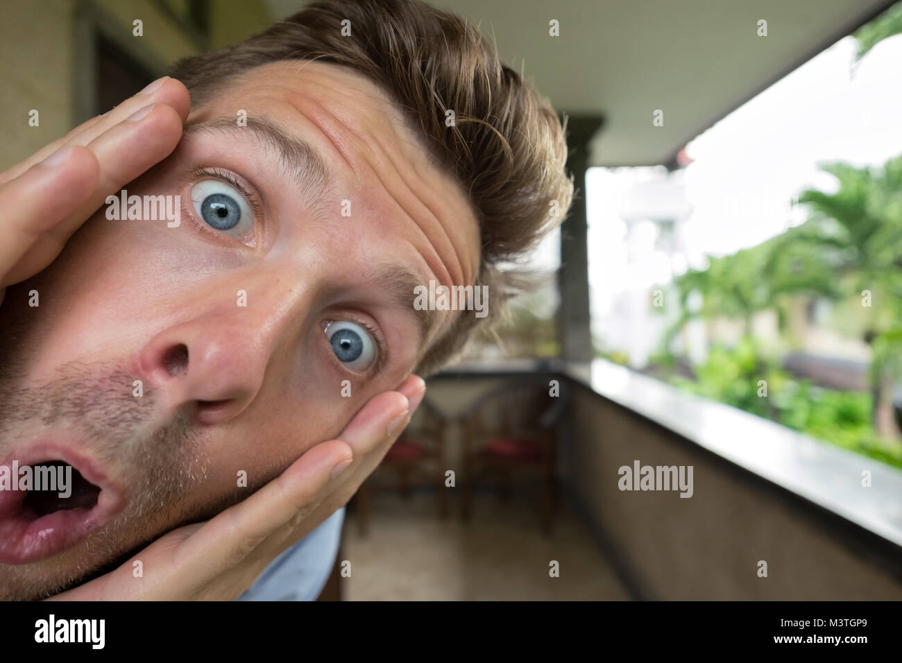 Panik Mann ist schockiert. Sein Gesicht ist in der Nähe von Kamera. Er öffnet den Mund, lassen Sie sich überraschen Stockfoto