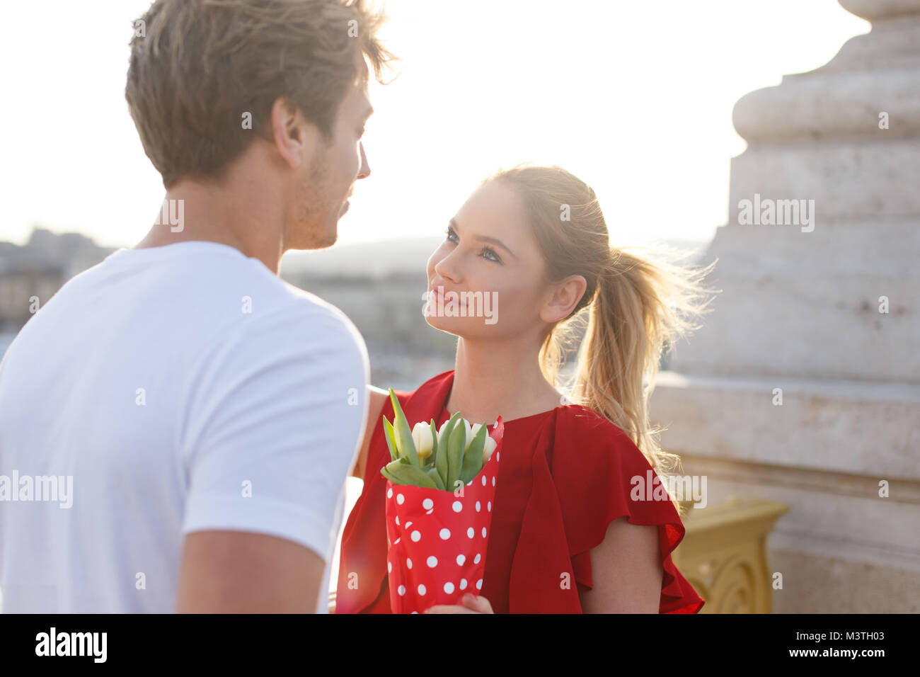 Junges Paar dating bei srping Outdoor, Frau mit Blumenstrauß Stockfoto