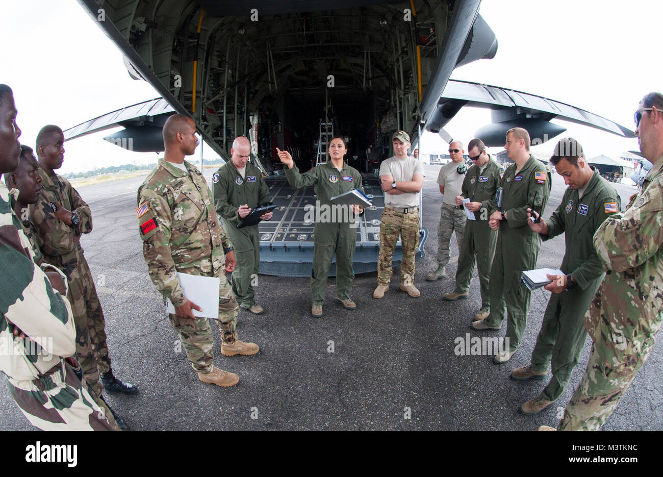 Us Air Force Reserve Maj. Elisa Klitzke (Mitte), ein Pilotprojekt mit der Luftbrücke 731st Squadron, spricht mit Ihr aircrew, US-Armee und Streitkräften der Gabunischen Republik jumpmasters jumpmasters vor der Durchführung zum lastenabwurf von einer C-130 Hercules während dieser Jahre zentrale Accord Übung in Libreville, Gabun am 15. Juni 2016. Us-Armee Afrika übung Zentrale Accord 2016 ist eine jährliche, kombiniert, gemeinsame militärische Übung, die zusammen bringt Partner Nationen zu Praxis und Kenntnisse in der Durchführung von friedenserhaltenden Maßnahmen zeigen. (DoD Nachrichten Foto durch TSgt Brian Kimball) 160623-F-QP 401-023 Stockfoto